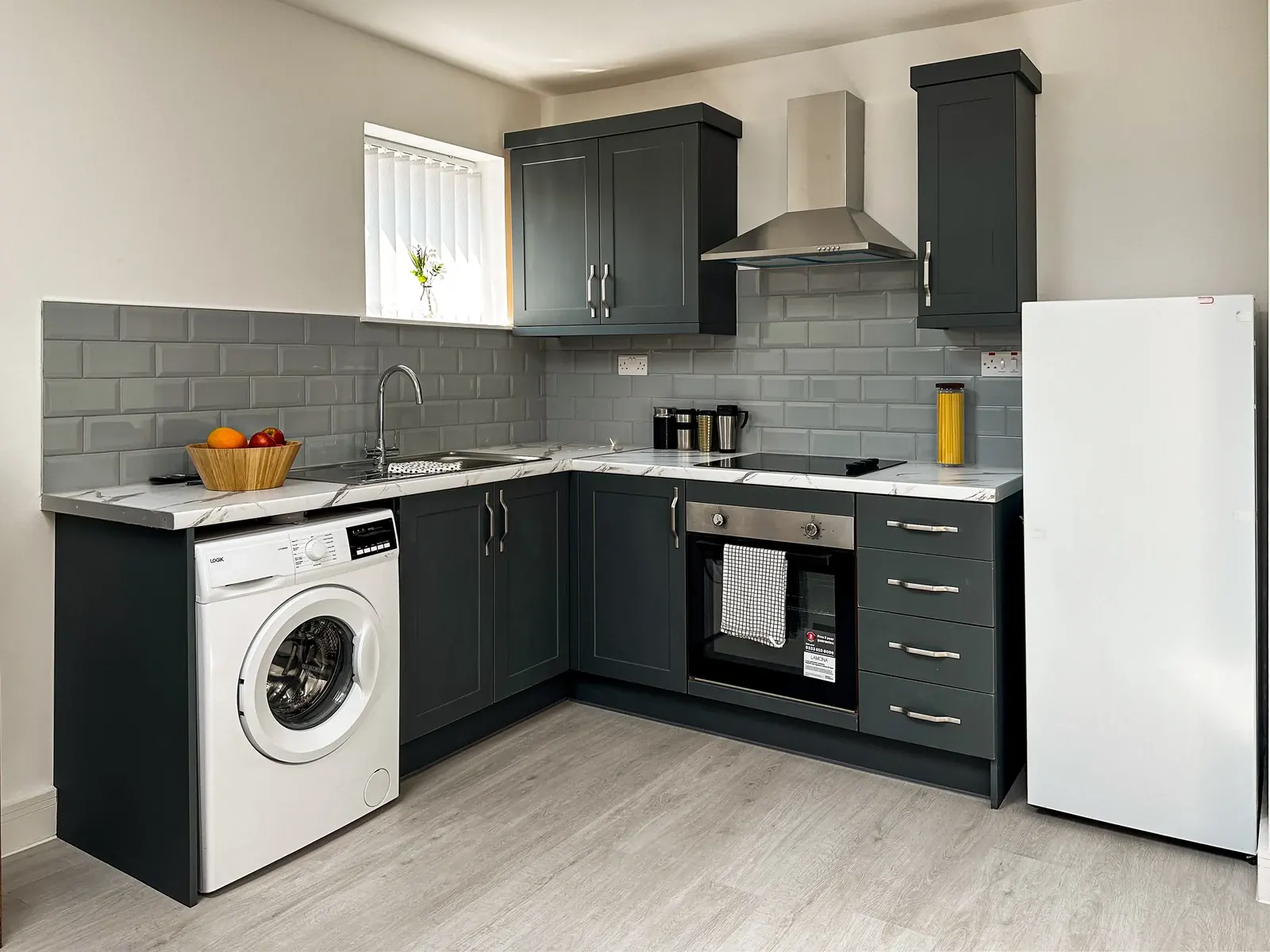 Charcoal cabinetry, fitted worktops and tiled splashback